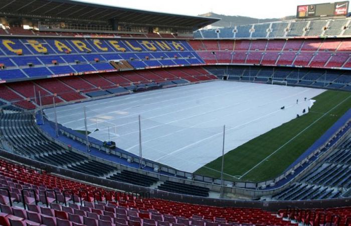 Los trabajadores se golpean con postes de madera en el sitio de construcción del estadio.