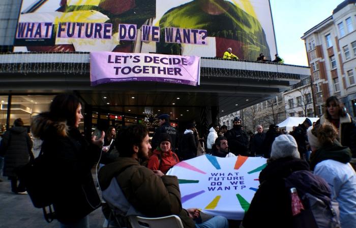 “¿Qué futuro queremos”? Activistas despliegan una enorme pancarta en el Inno de la rue Neuve para denunciar el consumo excesivo durante el Black Friday