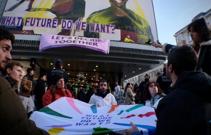 “¿Qué futuro queremos”? Activistas despliegan una enorme pancarta en el Inno de la rue Neuve para denunciar el consumo excesivo durante el Black Friday