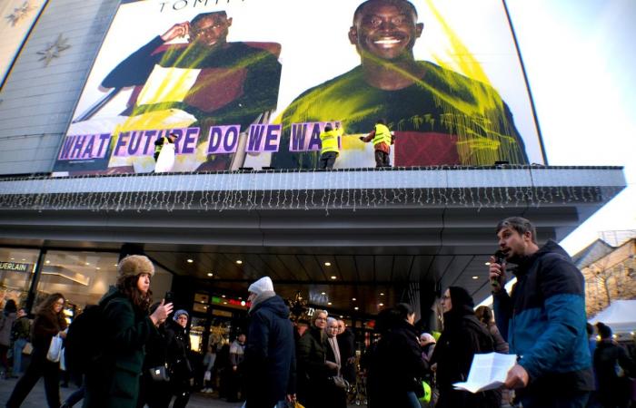 “¿Qué futuro queremos”? Activistas despliegan una enorme pancarta en el Inno de la rue Neuve para denunciar el consumo excesivo durante el Black Friday