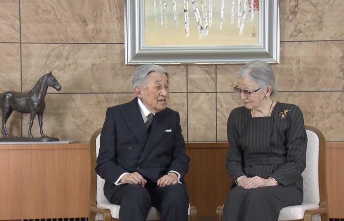 El emperador Akihito posa frente al emblema de su esposa en su 91 cumpleaños