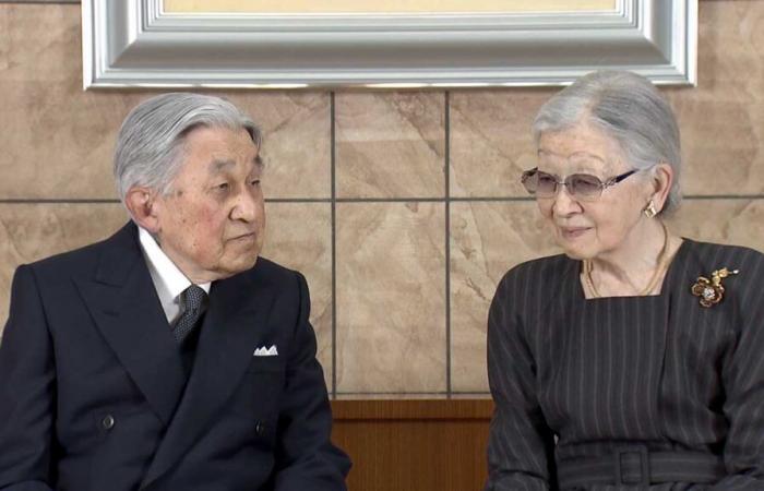 El emperador Akihito posa frente al emblema de su esposa en su 91 cumpleaños