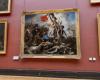 En el Louvre, carteles pegados junto al cuadro “La libertad guiando al pueblo”